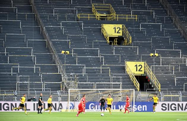 Le milieu du Bayern Munich, Joshua Kimmich (centre gauche) et le défenseur de Dortmund, Mats Hummels (centre droit) se disputent le ballon lors du match de Bundesliga à Dortmund, le 26 mai 2020  [Federico Gambarini / POOL/AFP]