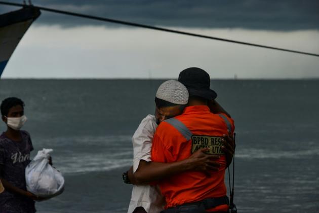 Un Rohingya embrasse un fonctionnaire indonésien à son arrivée dans le village de Lancok, dans la région d'Aceh en Indonésie, le 25 juin 2020, après une longue dérive en mer avec une centaine d'autres réfugiés [CHAIDEER MAHYUDDIN / AFP]