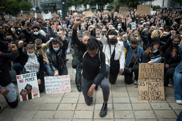 Des manifestants, genou à terre, lève le poing, lors d'un rassemblement contre le racisme et les violences policières, le  juin 2020 à Nantes [Loic VENANCE / AFP/Archives]
